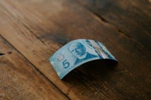 Canada's Best Signup Bonuses - Canadian $5 bill on a wooden table