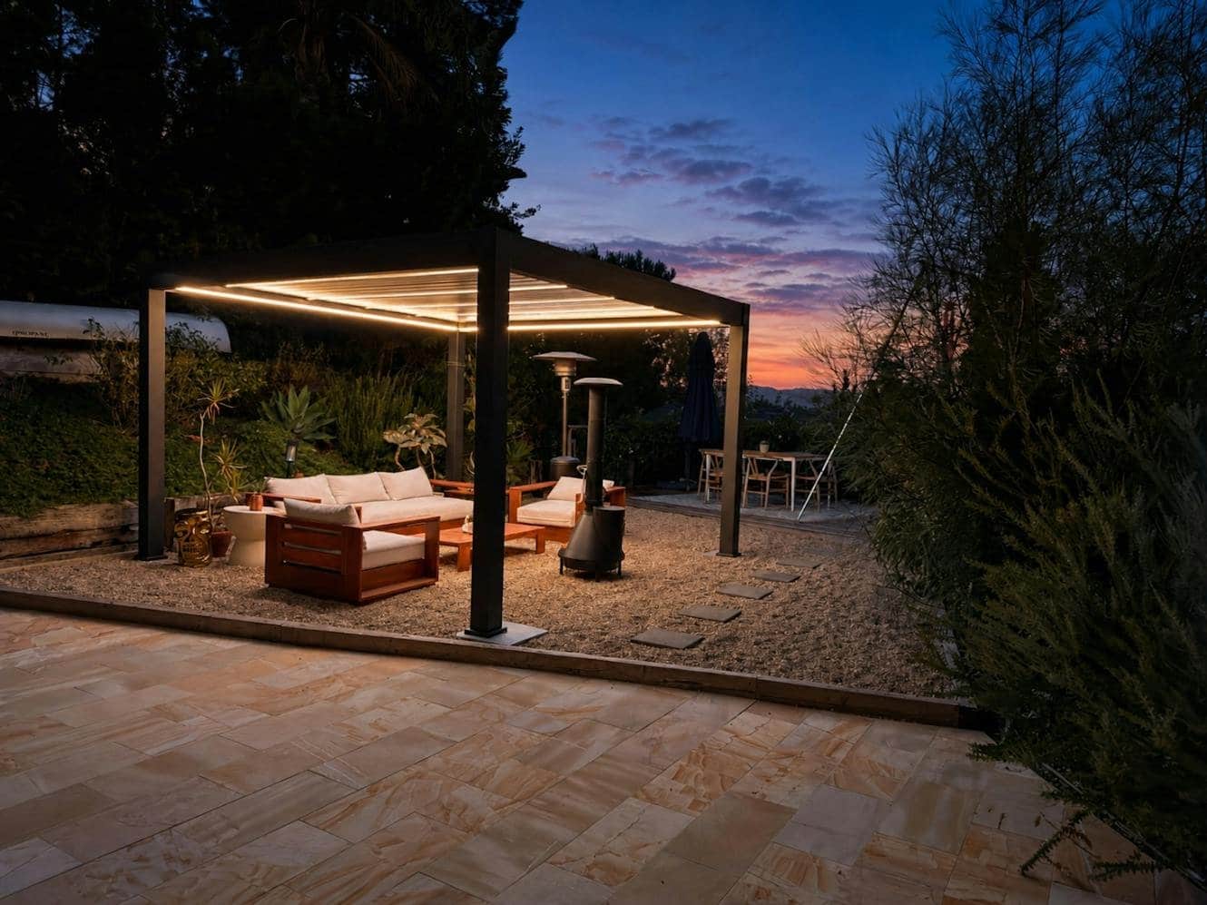 Lit pergola and fire pit area at the Kindred canyon house